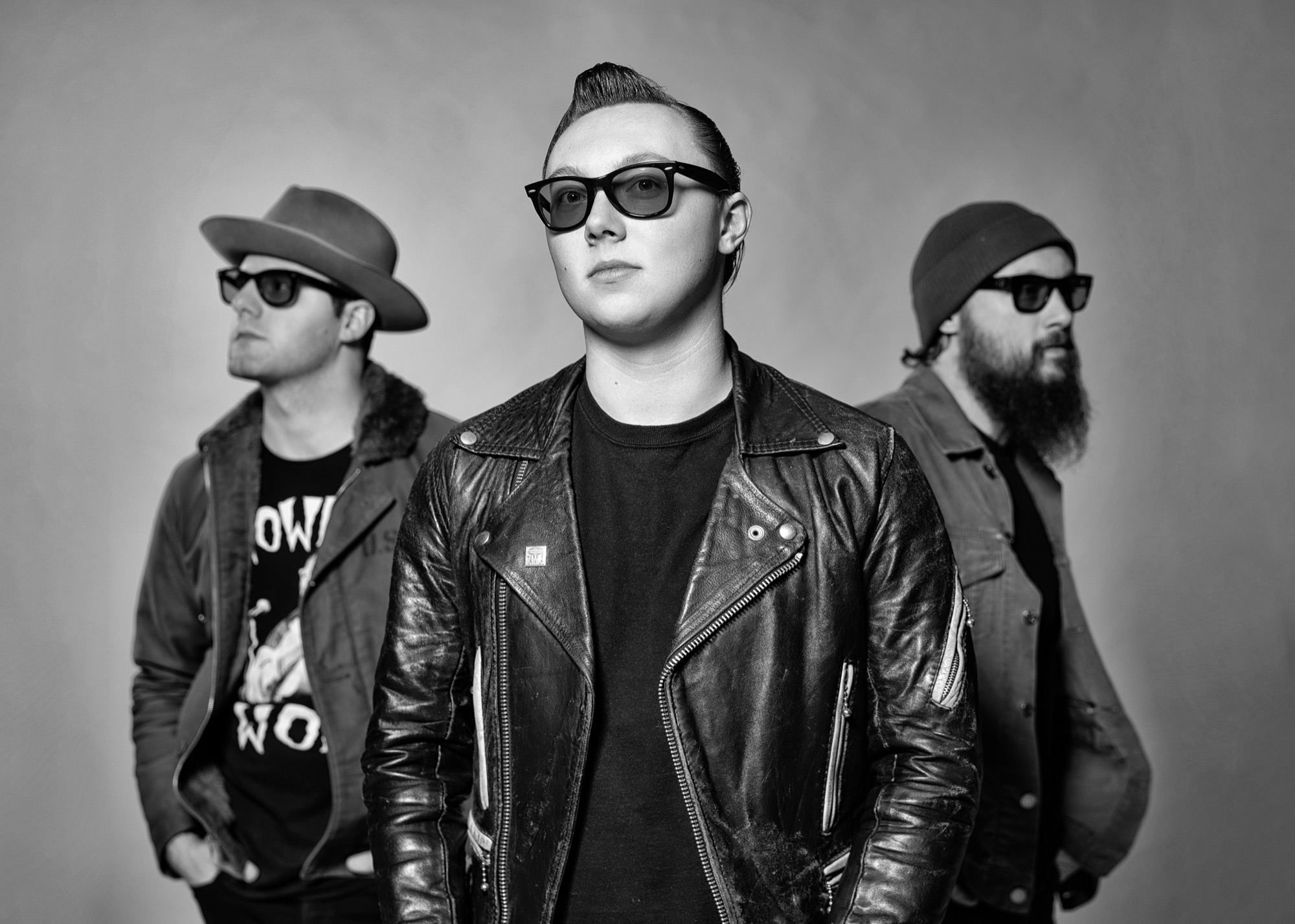 Trio band portrait in black and white, three musicians in sunglasses and leather jackets